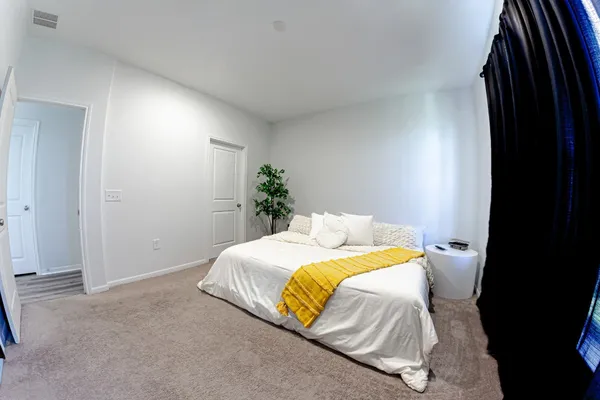 a bedroom with a bed and a painting on the wall