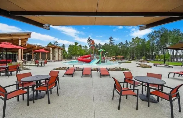 a group of chairs sitting in patio with a table and chairs under an umbrella