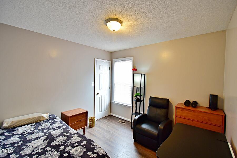 7120 Spanglers Spring Way Raleigh, NC 27610 - Photo 16 of 18 a bedroom with furniture and wooden floor