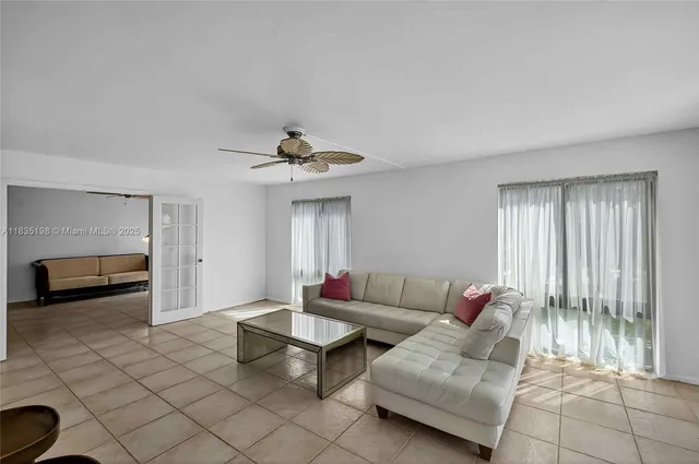 a living room with furniture and a ceiling fan