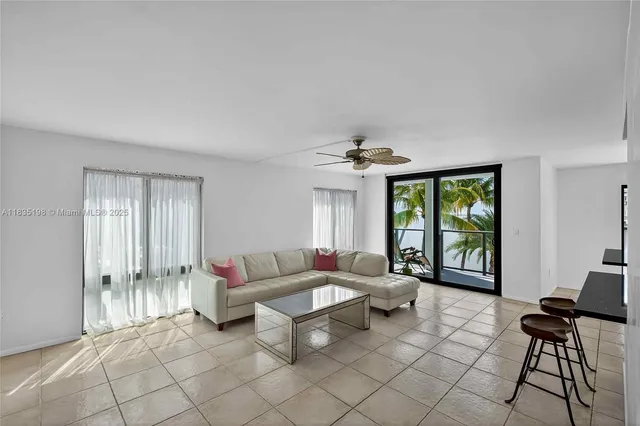 a living room with furniture and floor to ceiling windows