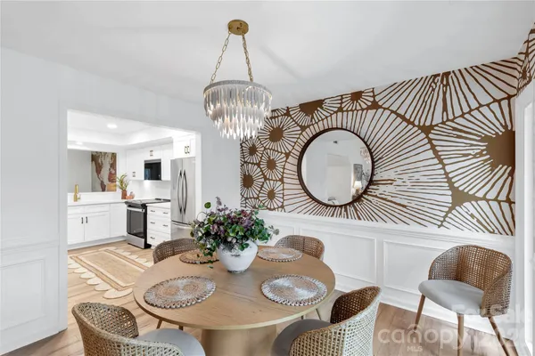 a view of a dining room with furniture a chandelier and wooden floor