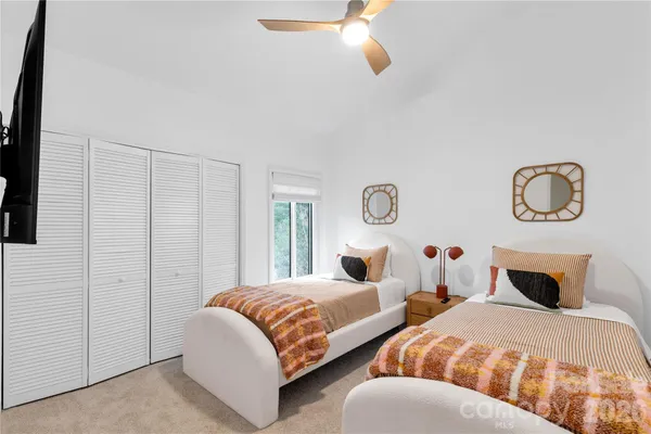 a bedroom with two beds and a chandelier