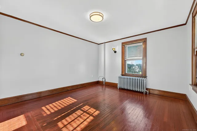 a view of room with window and wooden floor