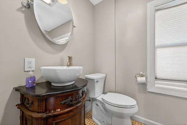 a bathroom with a toilet a sink and a mirror