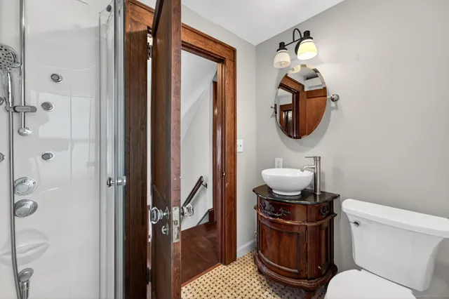 a bathroom with a toilet mirror and vanity