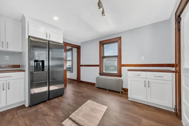 a kitchen with white cabinets and refrigerator