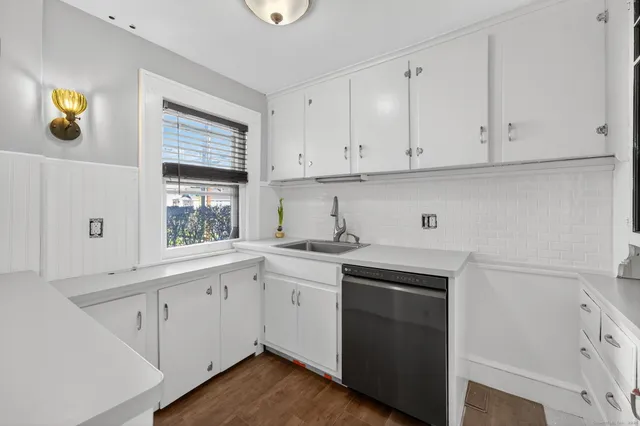 a kitchen with cabinets appliances a sink and a window