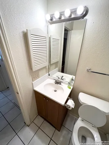 a bathroom with a sink toilet and mirror