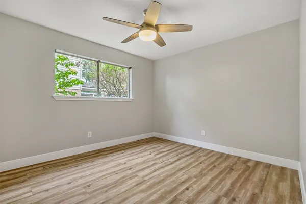 a view of an empty room with wooden floor