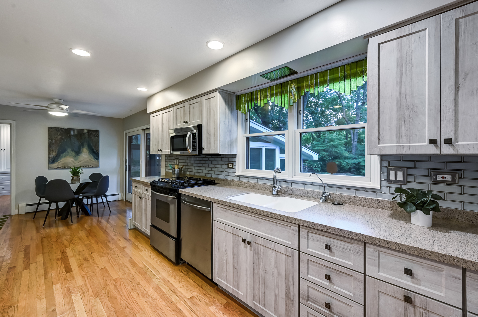 1200 Oak Hill Road Downers Grove, IL 60515 - Photo 7 of 24 a kitchen with a sink a counter top space stainless steel appliances and a large window