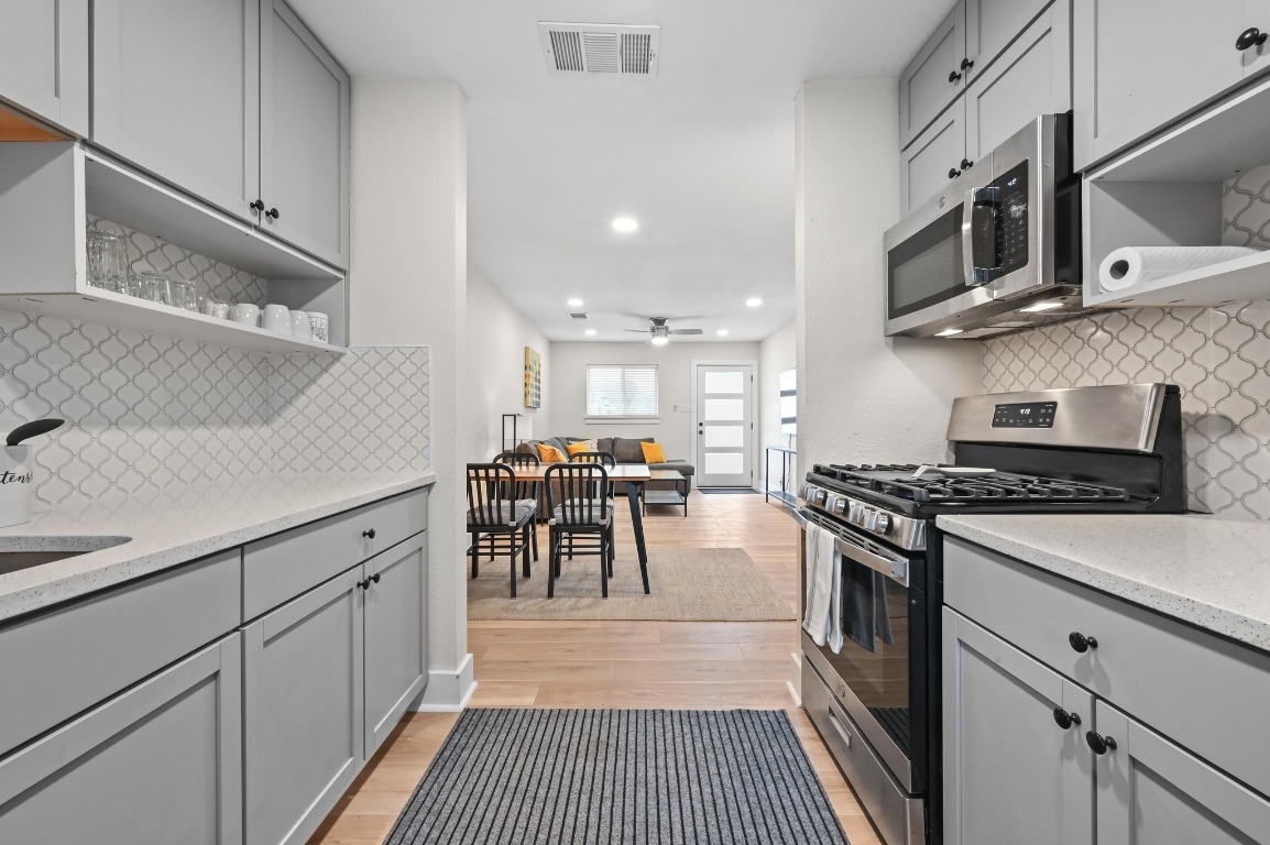 1307 Falcon Cove, Unit A Austin, TX 78745 - Photo 14 of 21 Kitchen with open shelves, gray cabinets, stainless steel appliances, and recessed lighting