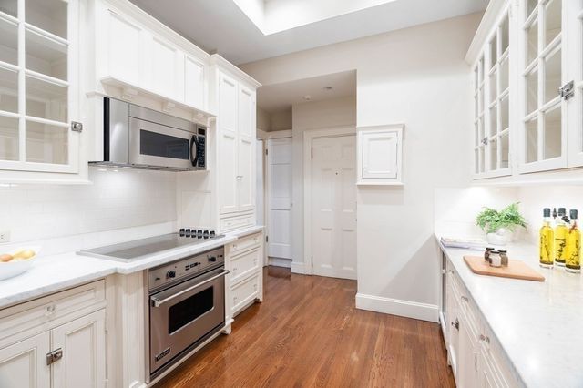 a kitchen with stainless steel appliances a stove microwave and sink