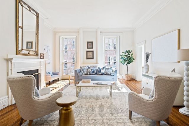 a living room with furniture a fireplace and a large window