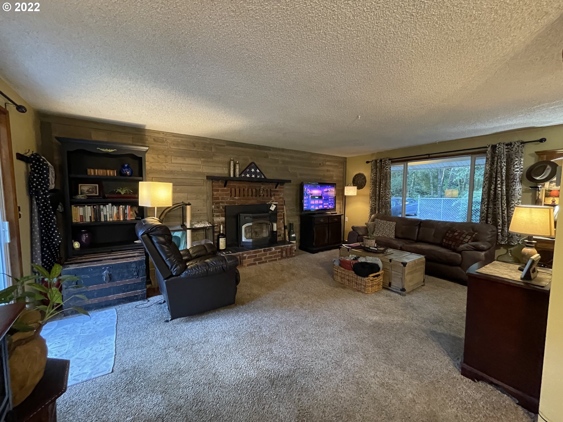 73860 Debast Road Rainier, OR 97048 - Photo 5 of 30 a living room with furniture a flat screen tv and a fireplace