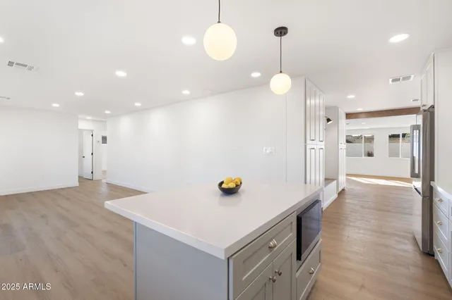 a kitchen that has a lot of cabinets and wooden floor