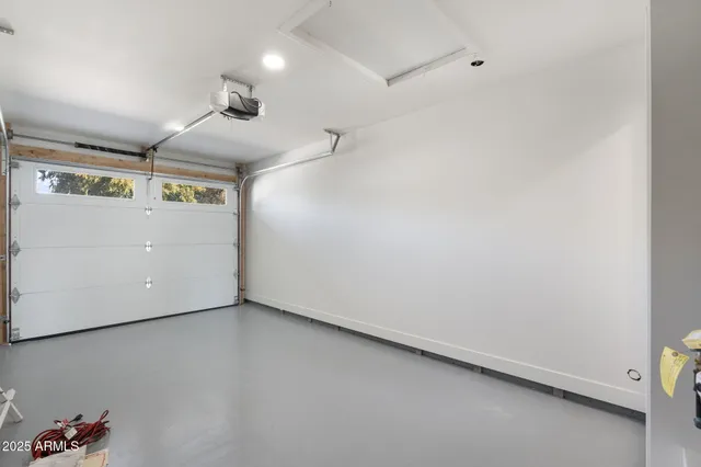 a spacious bedroom with a large bed a chandelier and dresser