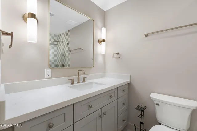 a bathroom with a sink a toilet and a mirror