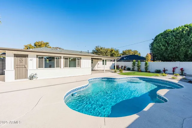 a swimming pool with outdoor seating and yard