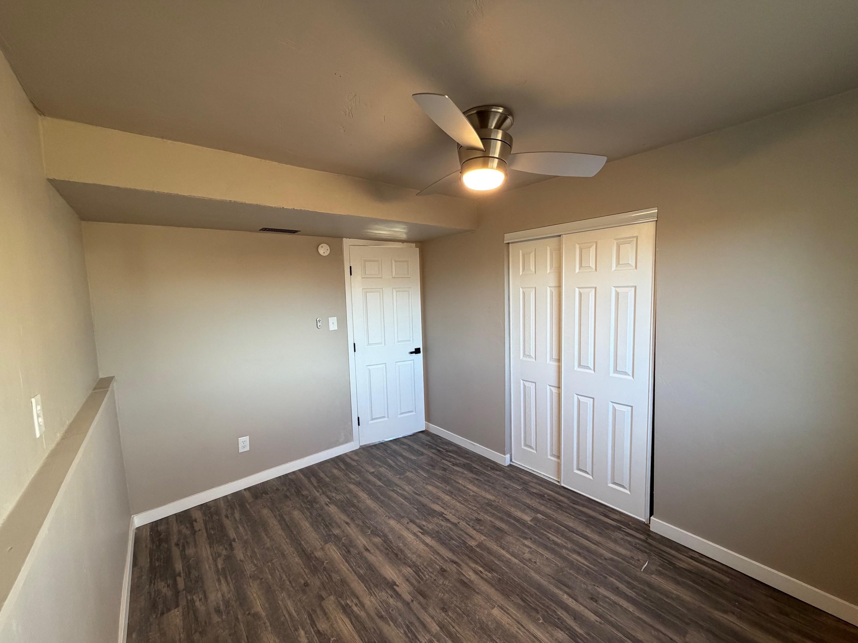 558 1/2 31 3/4 Road Grand Junction, CO 81504 - Photo 12 of 25 a view of an empty room with wooden floor and a ceiling fan