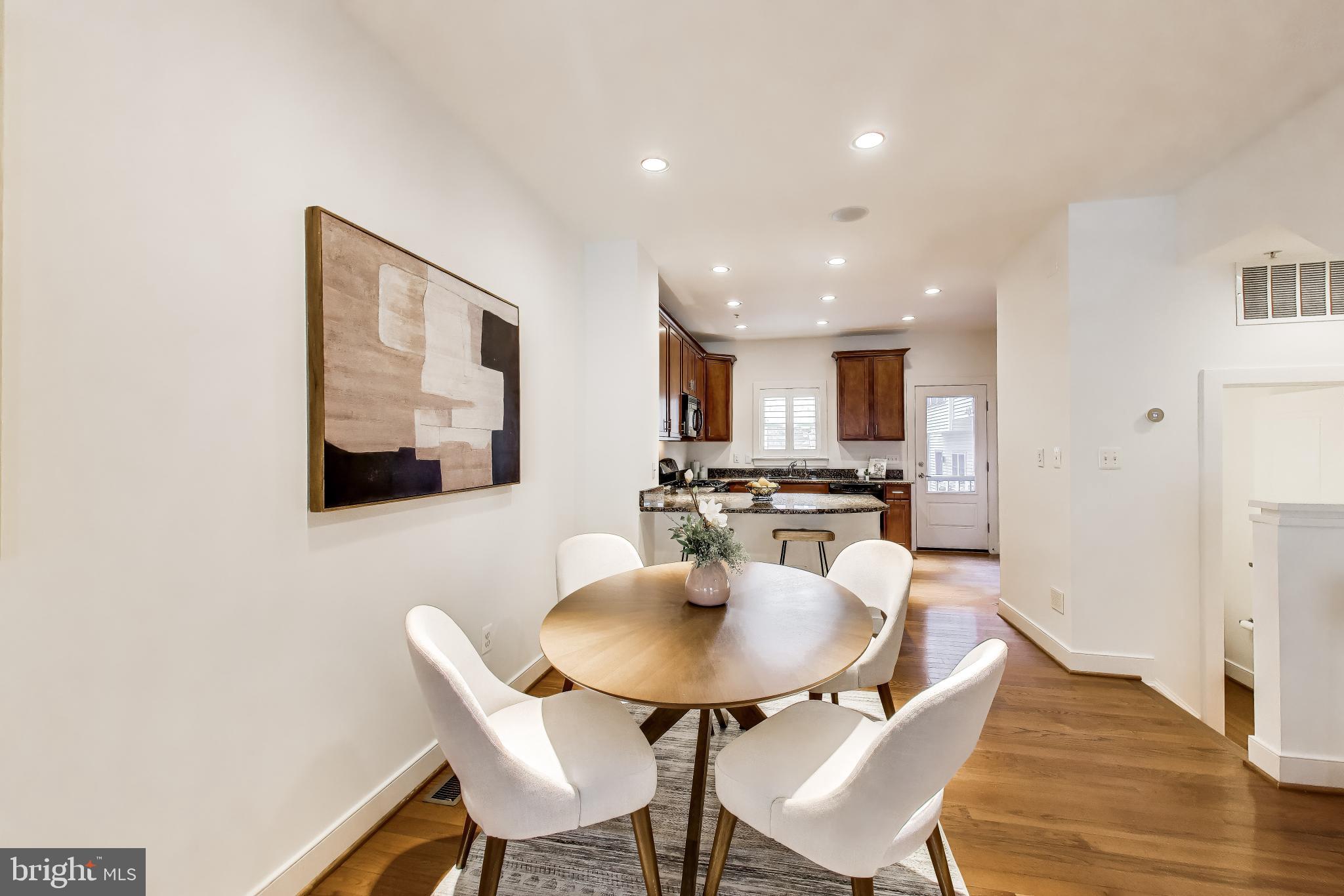4405 Longfellow Street Hyattsville, MD 20781 - Photo 14 of 44 a kitchen with a dining table chairs and a dining table with wooden floor