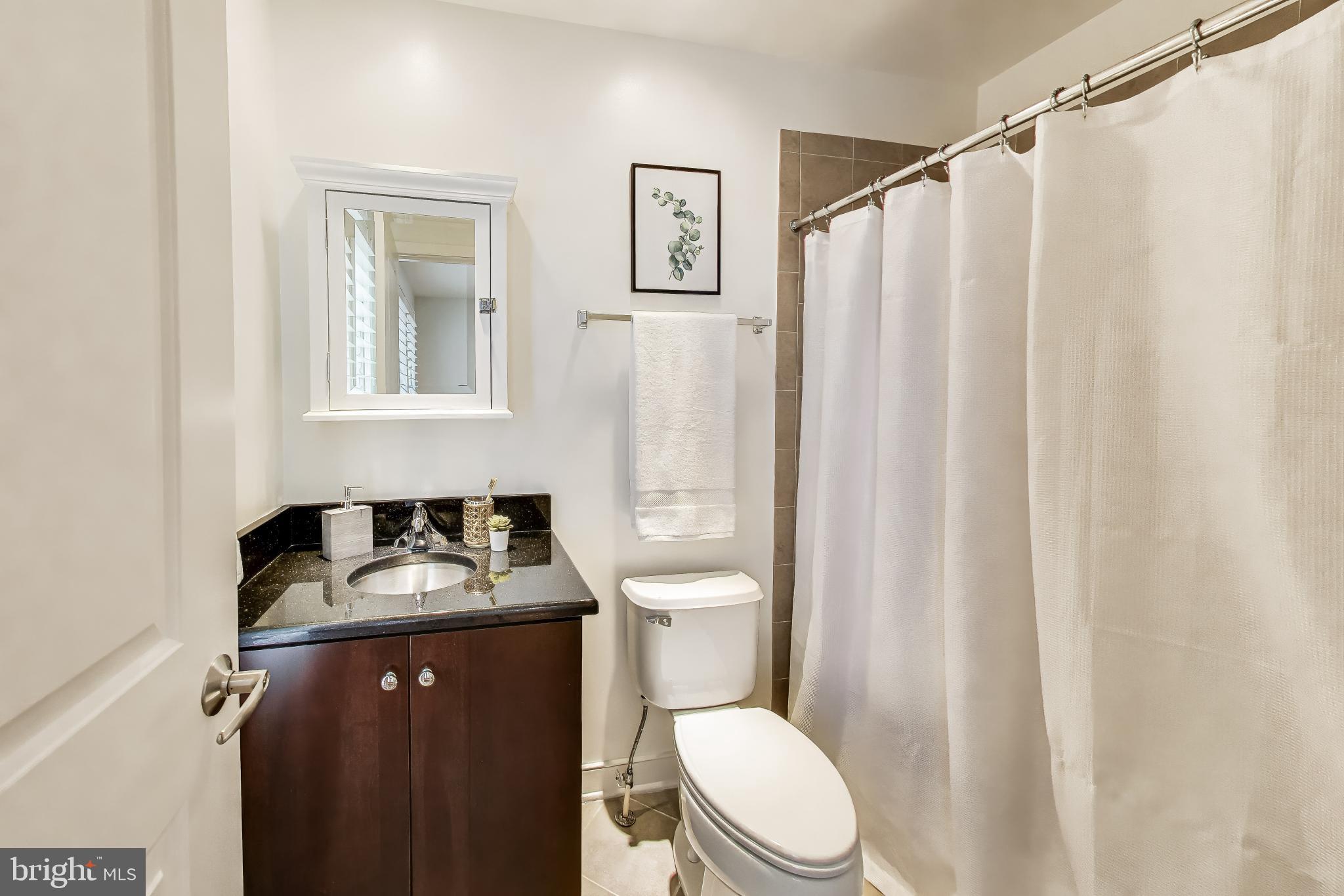 4405 Longfellow Street Hyattsville, MD 20781 - Photo 37 of 44 a bathroom with a granite countertop sink toilet and shower