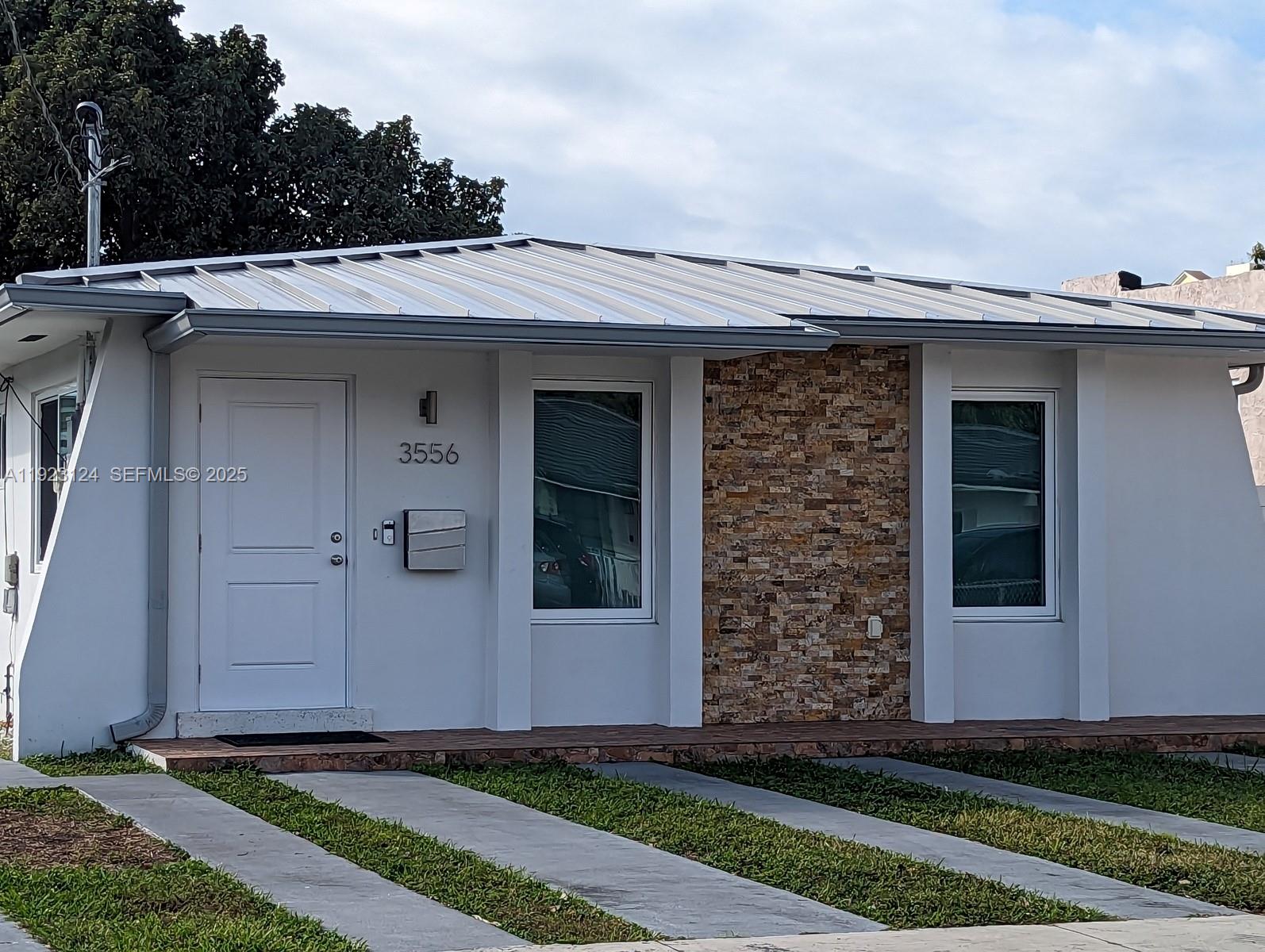 a view of a house with a small yard and wooden floor and fence