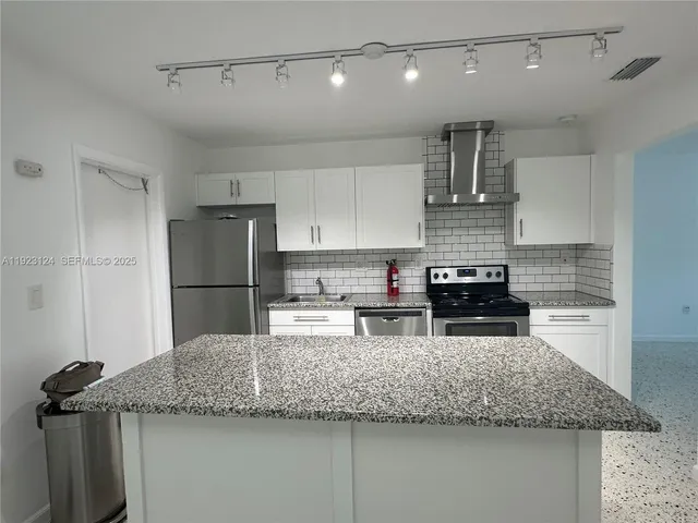 a kitchen with refrigerator and stove