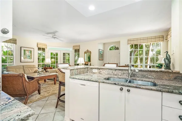 a dining hall with stainless steel appliances granite countertop a sink and cabinets