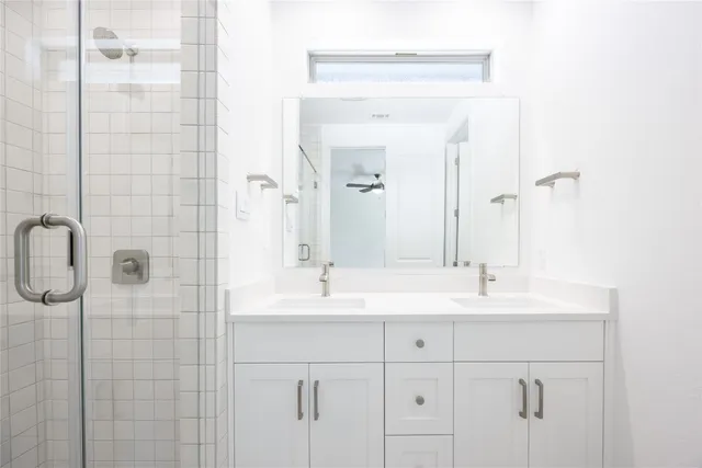 a bathroom with a shower sink and mirror