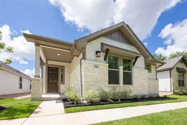 a front view of a house with a yard and potted plants