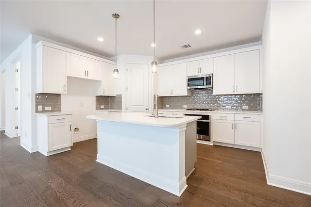 a kitchen with white cabinets and stainless steel appliances