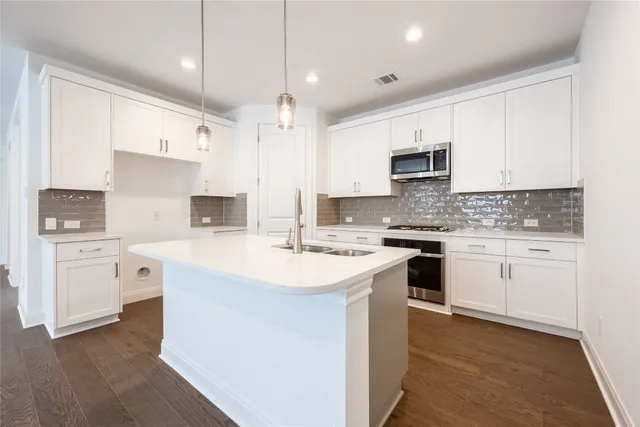 a kitchen with white cabinets sink and stainless steel appliances