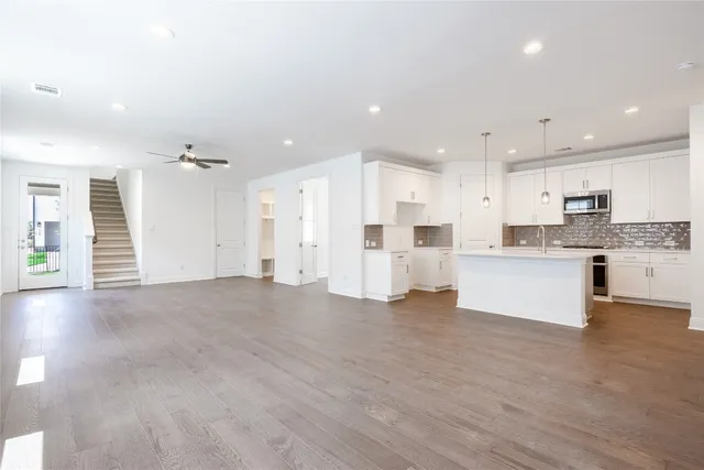 a view of kitchen with kitchen island white cabinets and stainless steel appliances