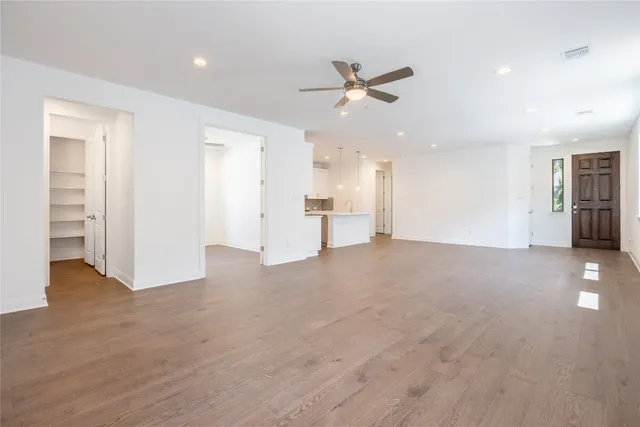 an empty room with a window and a fan