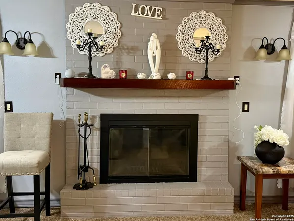 a living room with a fireplace a chandelier and a mirror