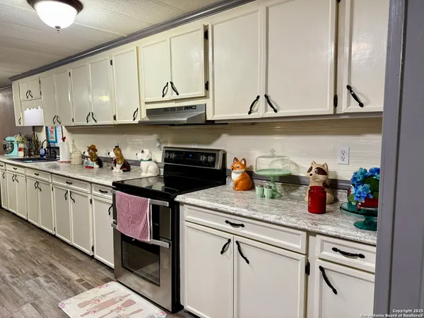 a kitchen with stainless steel appliances granite countertop a dining table and chairs