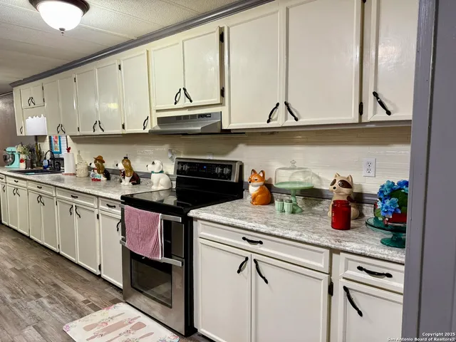 a kitchen with stainless steel appliances granite countertop a dining table and chairs