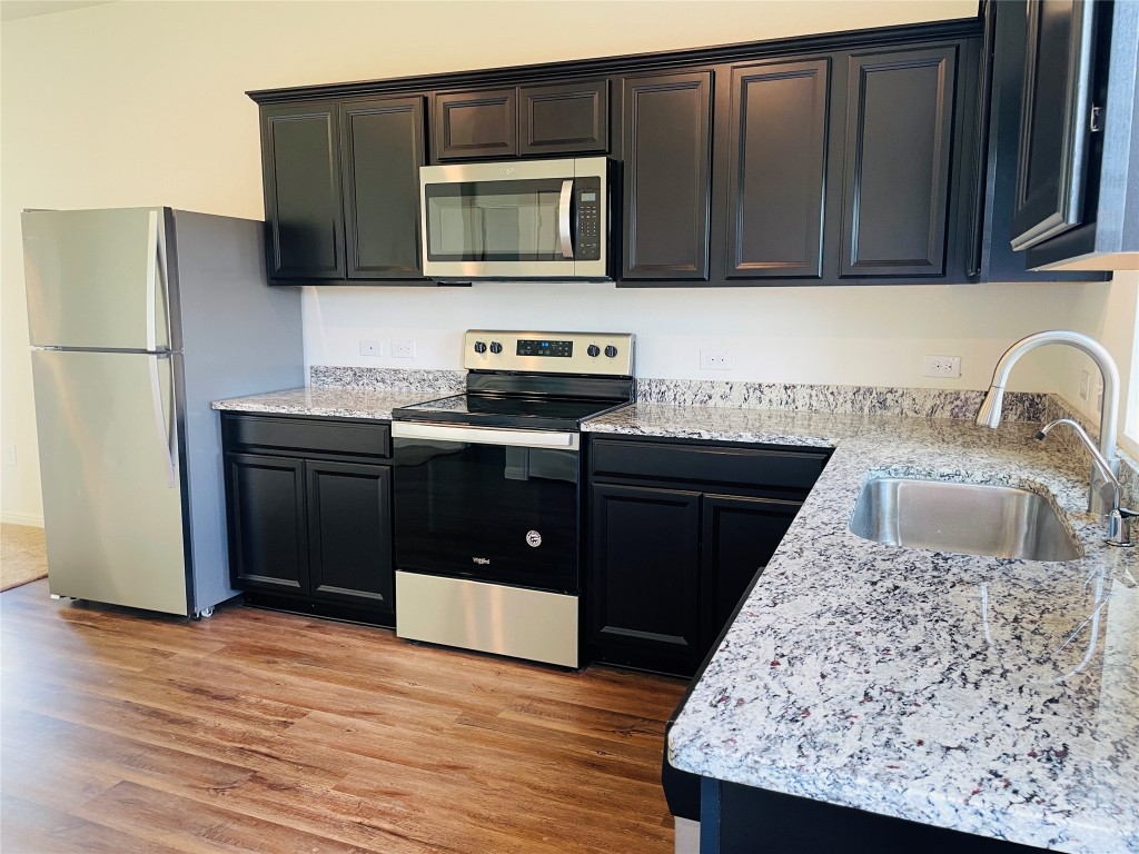 532 Peony Court Jarrell, TX 76537 - Photo 6 of 19 a kitchen with stainless steel appliances granite countertop a sink stove and refrigerator