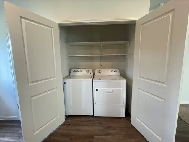 a utility room with wooden floor washer and dryer