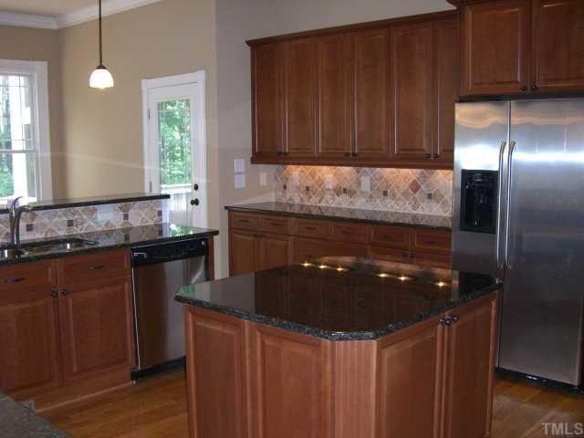 7204 Sparhawk Road Wake Forest, NC 27587 - Photo 3 of 12 Large kitchen features granite tops, travertine back splash and spacious center island. Refrigerator included!
