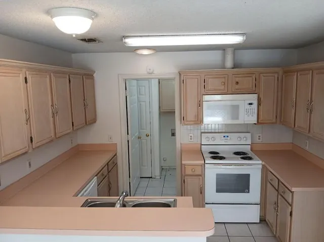 a kitchen with white cabinets and white appliances