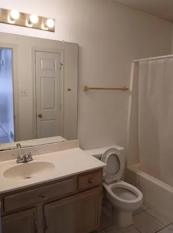 a bathroom with a granite countertop sink toilet and a mirror
