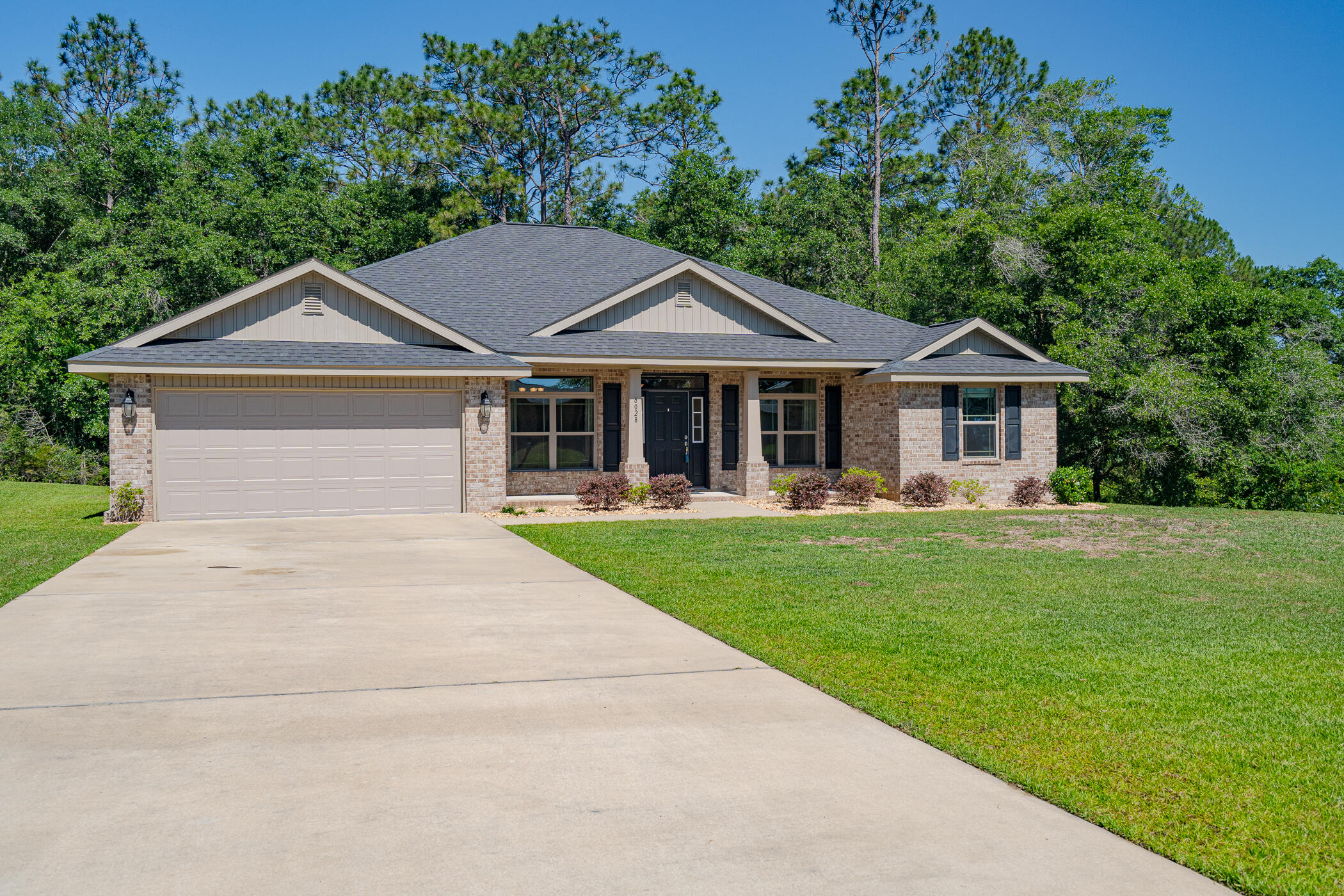 6028 Hidden Valley Road Crestview, FL 32539 - Photo 1 of 45 a front view of a house with a garden and trees