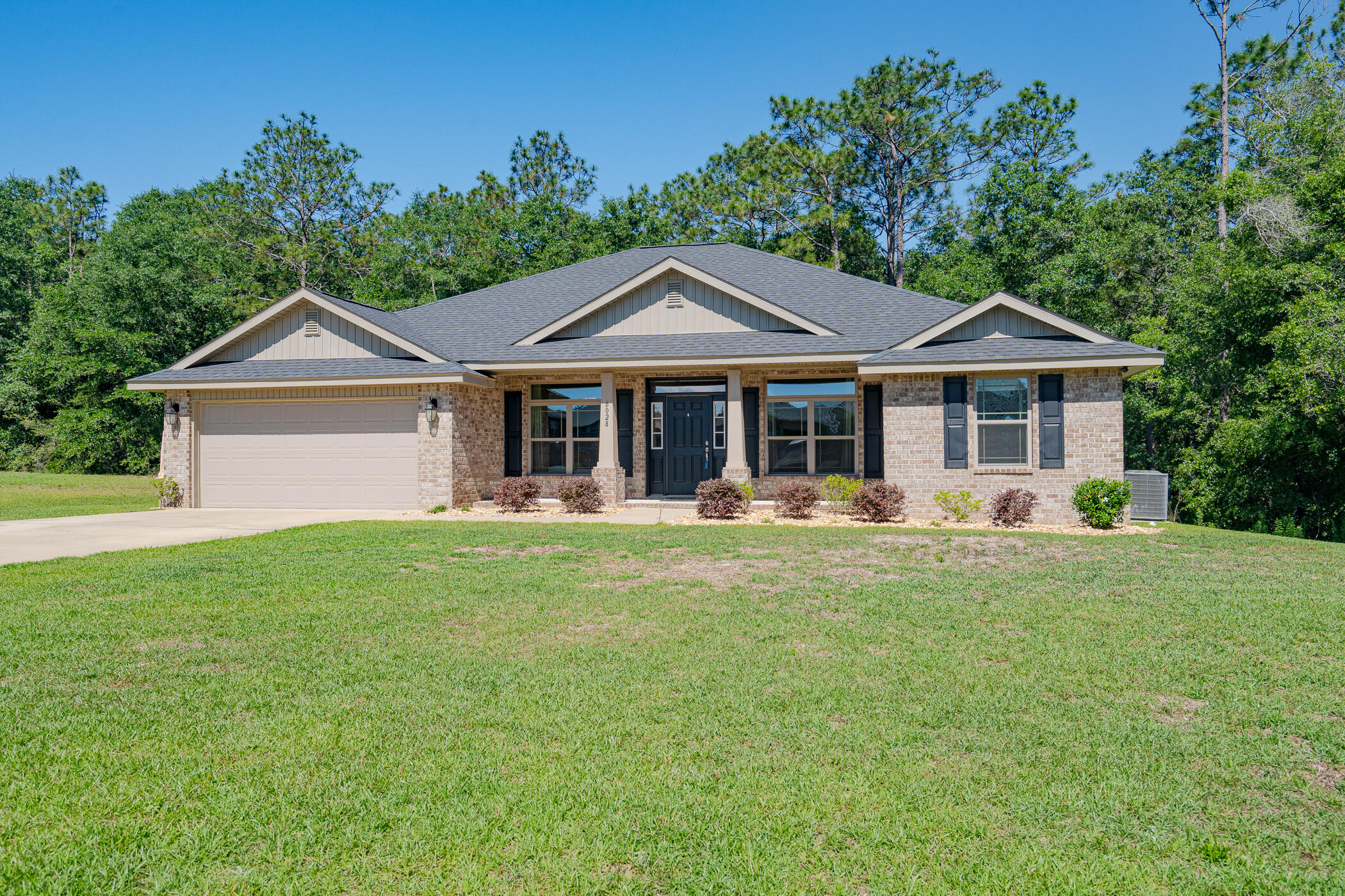 6028 Hidden Valley Road Crestview, FL 32539 - Photo 3 of 45 a front view of a house with a garden
