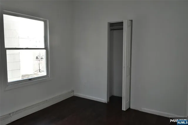 a view of a house with a small yard and large trees