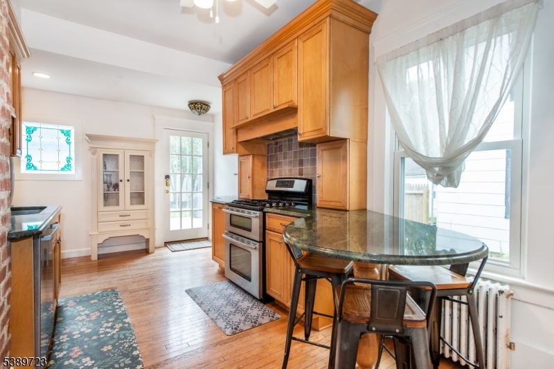 41 Anderson Hill Road Bernardsville, NJ 07924 - Photo 6 of 15 a kitchen with stainless steel appliances granite countertop a stove a refrigerator a dining table and chairs with wooden floor