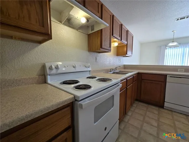 a white stove top oven sitting inside of a kitchen