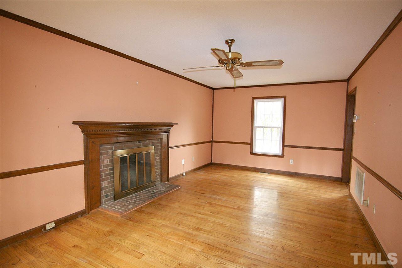 4612 Draper Road Raleigh, NC 27616 - Photo 4 of 16 a view of a livingroom with a fireplace and a ceiling fan