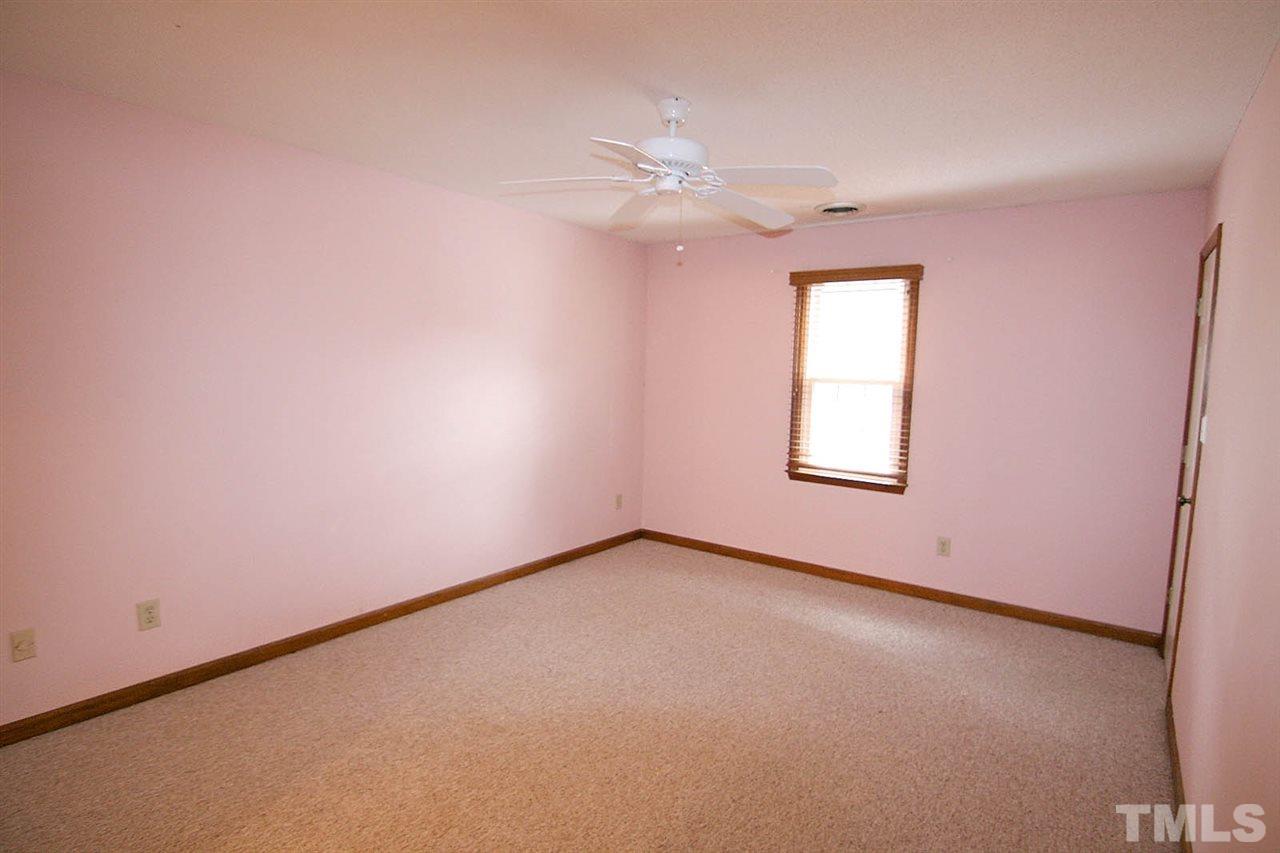 4612 Draper Road Raleigh, NC 27616 - Photo 9 of 16 an empty room with a chandelier fan and windows